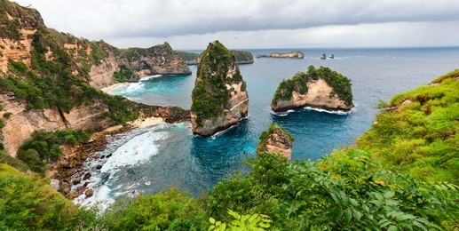 sea coast view with little house standing on the high cliff bring above sea and little rocky islets. atuh beach, nusa penida island. popular travel destination on bali holidays. indonesian background.