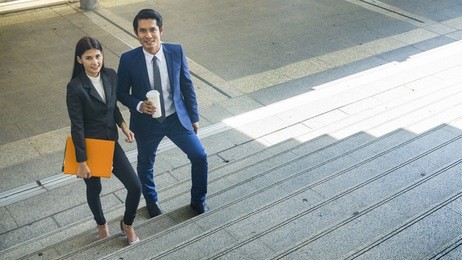 the smart business people of man and woman walk together in feeling happy at the outdoor pedestrian walkway space in the morning.