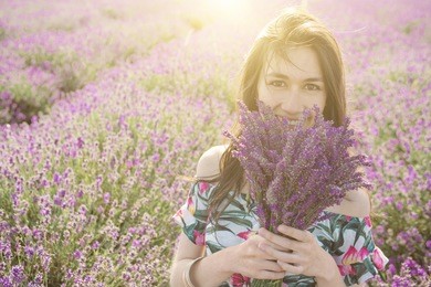 happy woman enjoying blooming lavender bouquet. summer sunset romantic mood. 
