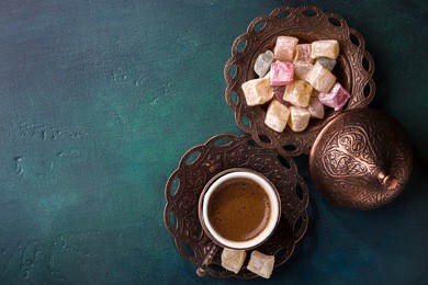 traditional turkish coffee  and turkish delight on dark green wooden background. flat lay.