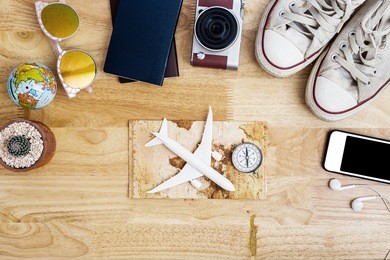 outfit and accessories of traveler on blue background with copy space, travel concept.overhead view of traveler's accessories, essential vacation items, travel concept on wooden background. top view
