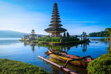 pura ulun danu bratan, hindu temple with boat on bratan lake landscape at sunrise in bali, indonesia.