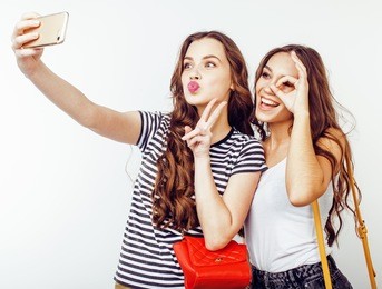 best friends teenage girls together having fun, posing emotional on white background, besties happy smiling, lifestyle people concept close up. making selfie