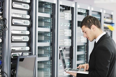 young it  engeneer business man with thin modern aluminium laptop in network server room