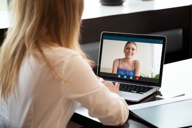 two young women chatting online by making video call on laptop, using videoconferencing app for communication with distance friend, studying online course, virtual learning, close up rear view