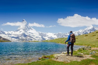 hiker with backpack on the triail near matterhorn. swiss alps
