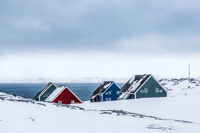 four colorful inuit houses among therocks in a suburb of arctic capital nuuk, greenland