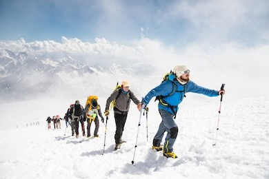a group of mountaineers climbs to the top of a snow-capped mountain