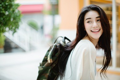 summer sunny lifestyle fashion portrait of young stylish hipster woman walking on the street, wearing cute trendy outfit