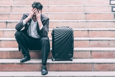 stress out handsome white male business man or sale man sitting on stair with black sale bag, thinking about not meeting his sale target. taken outdoor, apply urban looks effect. 
