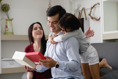 father's day.happy family ,activity of family at home .daughter have a gift for daddy.
parents stay home and have activity in family ,happy family concept