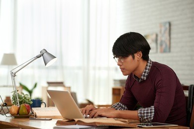 side view of asian young man concentrated on work