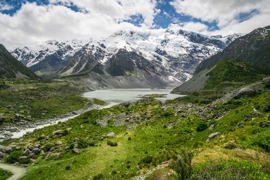 mountains, lakes and meadow landscape in cold climate country with snow and cloudy weather on the mountains. the landscape was shot in mt cook, new zealand, famous place for trekking and outdoors.