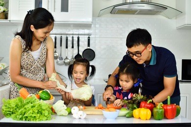 asian family cooking together in kitchen