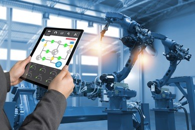 engineer hand using tablet, heavy automation robot arm machine in smart factory industrial with tablet real time process control monitoring system application. industry 4th iot concept.