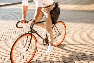 cropped picture of young african handsome man early morning with bicycle walking outdoors.