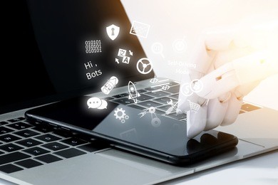 robot hand use mobile phone on laptop with flare light effect. robotic , artificial intelligence, chatbot technology concept. 