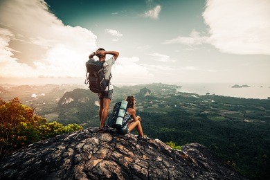 two hikers relax on top of a mountain with great view