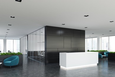 side view of a white reception desk standing in an open space office environment with a black wall, rows of computer tables and loft windows. 3d rendering mock up