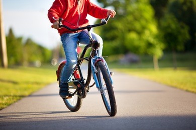 child on a bicycle at asphalt road in early morning