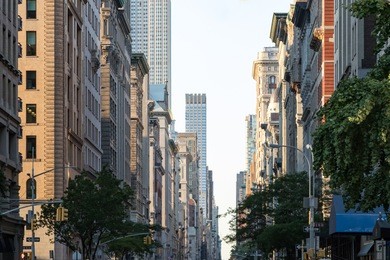 view down fifth avenue in manhattan, new york city with historic buildings lining both sides of the street in nyc