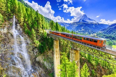 zermatt, switzerland. gornergrat tourist train with waterfall, bridge and matterhorn. valais region.