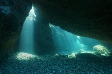 below big rocks underwater with sunbeam from hole, mediterranean sea, natural scene, pyrenees orientales, roussillon, france