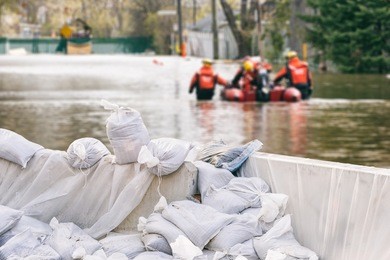 flood protection sandbags with flooded homes in the background (montage)