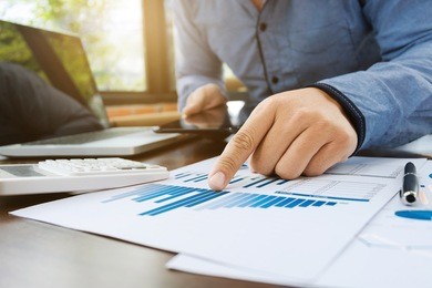 auditor or financial inspector working on sales performance report at modern workplace