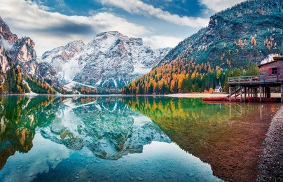 boat hut on braies lake with seekofel mount on background. colorful autumn sunrise of italian alps, naturpark fanes-sennes-prags, dolomite, italy, europe. traveling concept background.