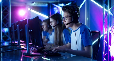 team of teenage gamers play in multiplayer pc video game on a esport tournament. captain gives commands into microphone, trying strategically win the game.