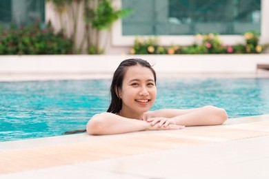 beautiful asian woman smiling in a swimming pool
