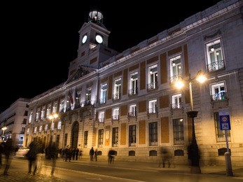 long exposure shot in puerta del sol (madrid, spain) at night, creating a motion blur effect of people walking.