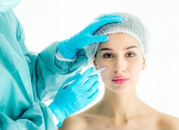 doctor drawing correcting lines on woman face before plastic surgery,beauty face size evaluate before surgery operation cosmetology, woman face with perforation lines before operation,