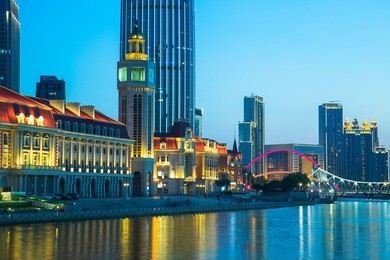 illuminated city waterfront downtown skyline with haihe river,tianjin,china.