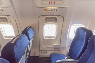 empty aircraft seats close to emergency door exit