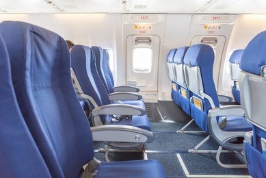 empty aircraft seats close to emergency door exit