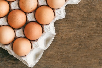 fresh eggs in egg rack put on wood table prepare for cooking in top view flat lay with copy space on wood table in still life concept for background or wallpaper. high protein food and delicious taste