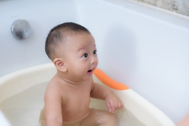 7 months cute baby boy bathing in the bath room.