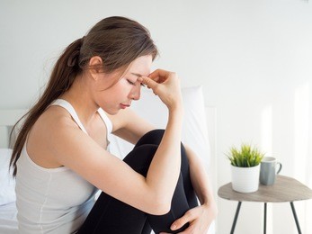 young beautiful asian woman headache on white bed, sad, stressed, crying, disappointed feeling in the morning
