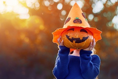 happy halloween! cute little child with a pumpkin in the park.