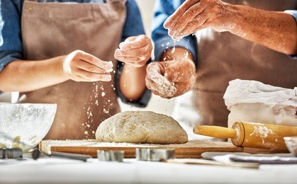 close up view of bakers are working. homemade bread. hands preparing dough on wooden table. 