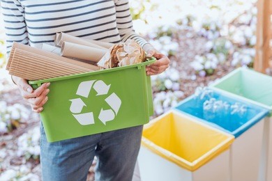 activist taking care of environment, sorting paper waste to proper recycling bin on terrace