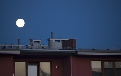 the roof of the flat block with the moon on the background