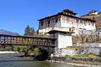 paro rinpung dzong, the traditional bhutan palace with wooden bridge across the river  paro chu near to the city paro, bhutan
