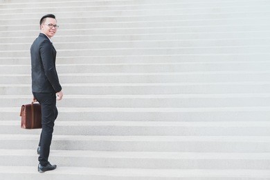 asian smart businessman walking up the stairs.concept of success business step.