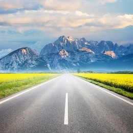 asphalt road among the summer field and mountain on horizon. beautiful countryside landscape