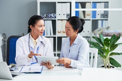 doctor explaining prescription to senior woman