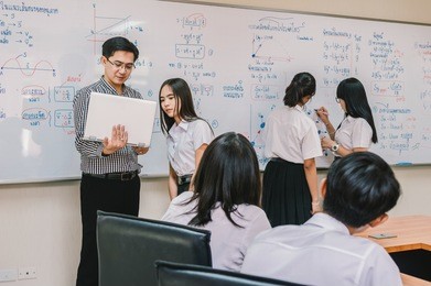 asian teacher giving lesson to group of college students in the classroom, university education concept