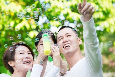 young happy asian family spending time together at the park.